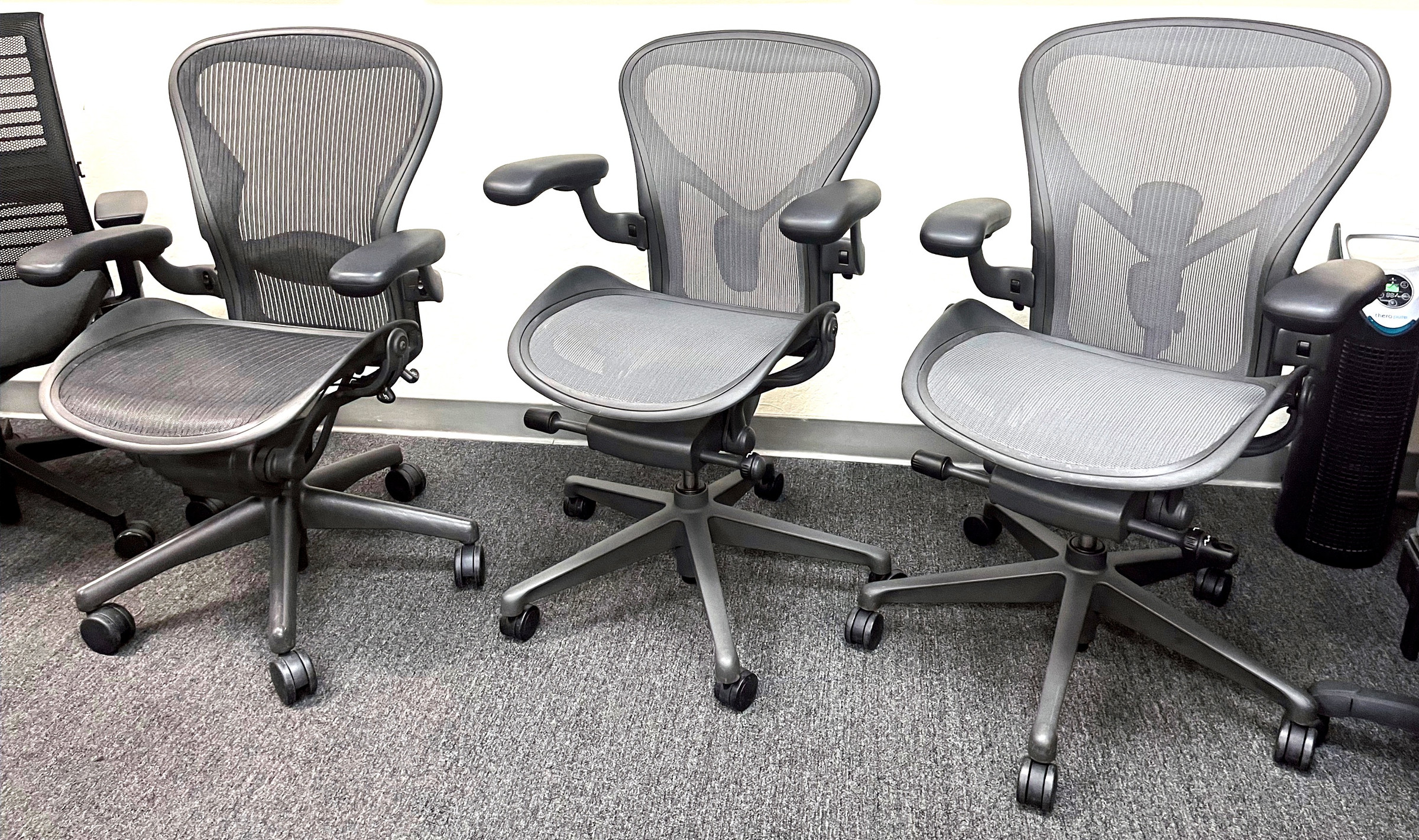 Used Herman Miller Aeron ergonomic chairs lined up in the BT Express San Jose showroom