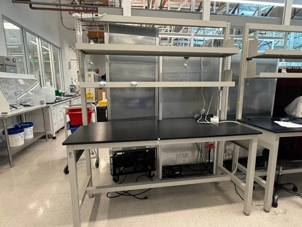 Lab bench with black top and overhead shelving in a working laboratory