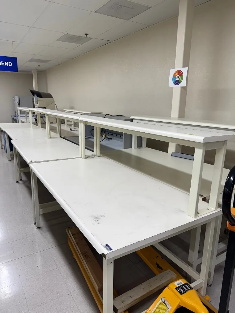 Row of used white lab benches with riser shelves